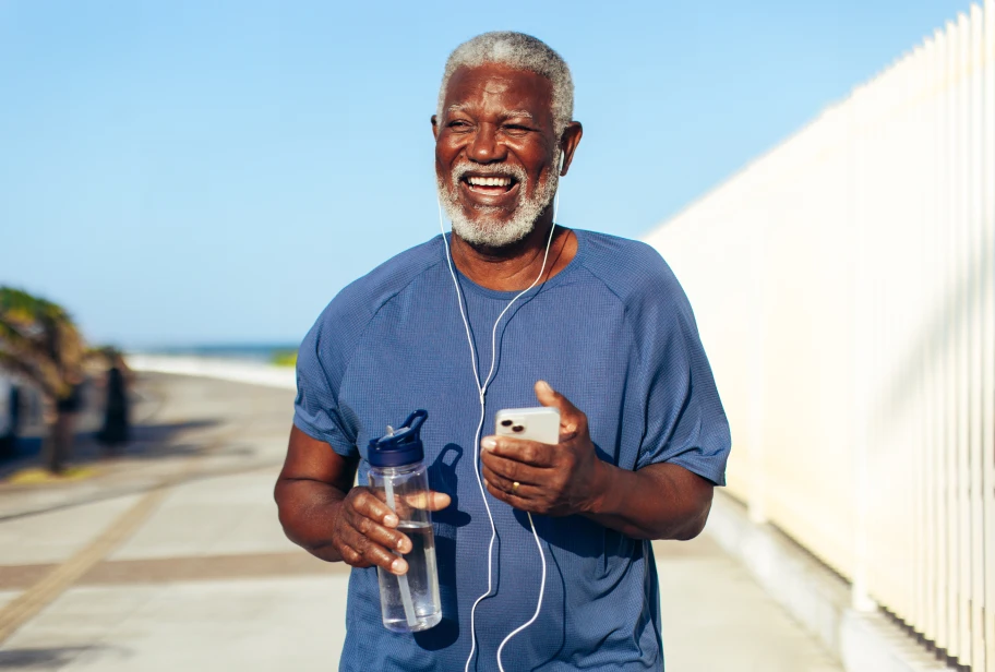 Person in blue t-shirt holding a water bottle on a beach
